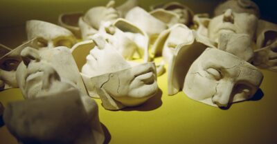 white masks floating over a yellow surface
