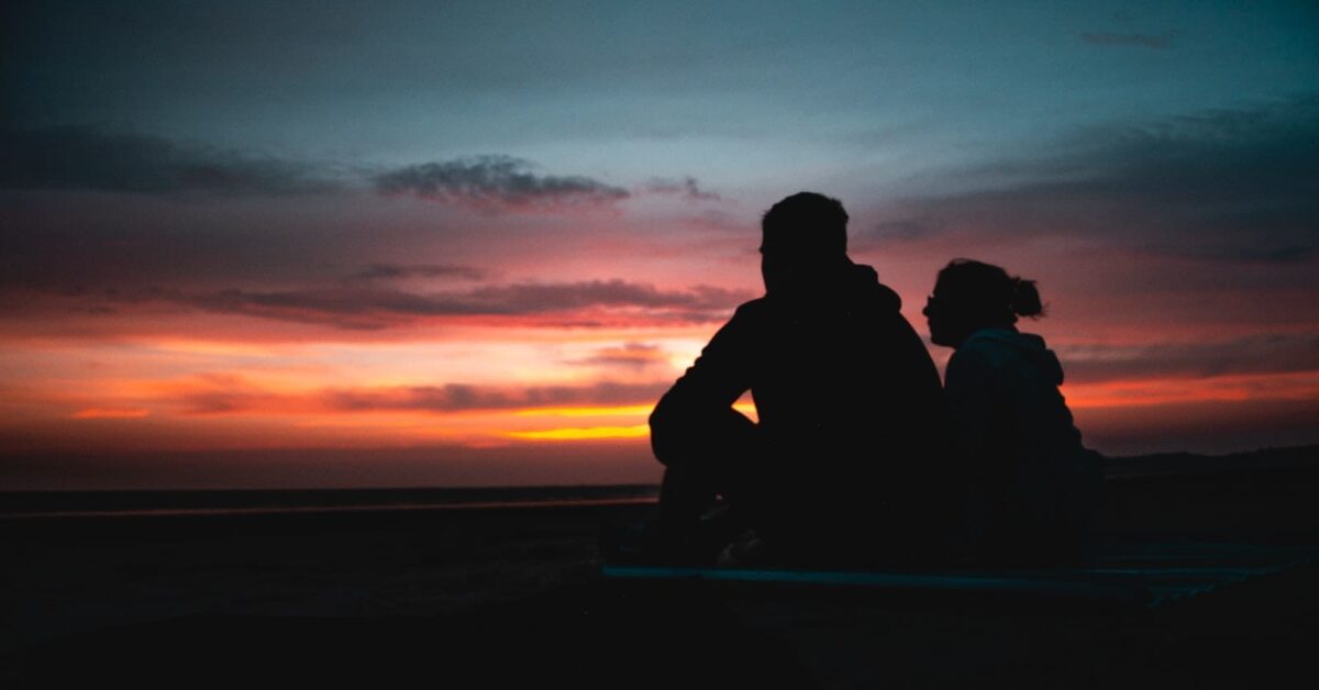 two persons sitting during golden hour, possibly lovers