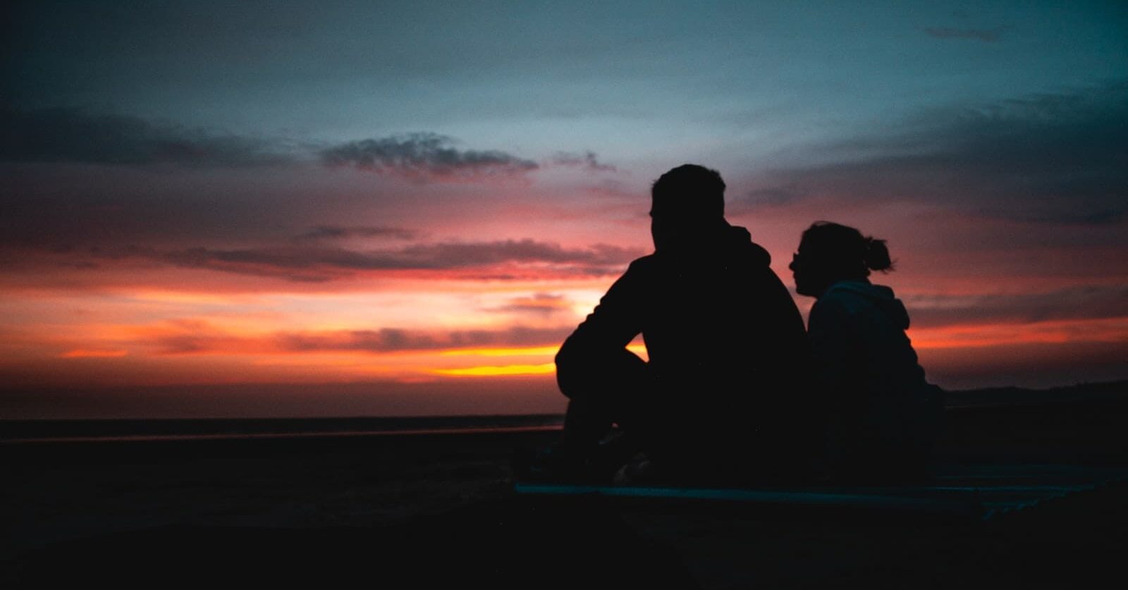 two persons sitting during golden hour, possibly lovers