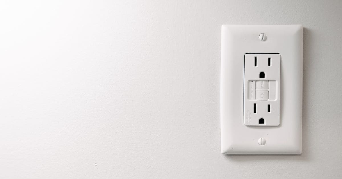 two plug points with switches, on a plain white wall