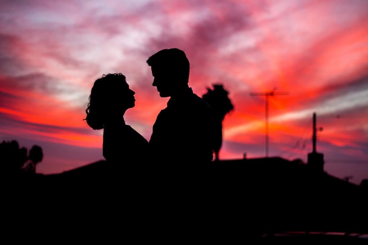 silhouette of man and woman facing each other during golden hour indicating lover