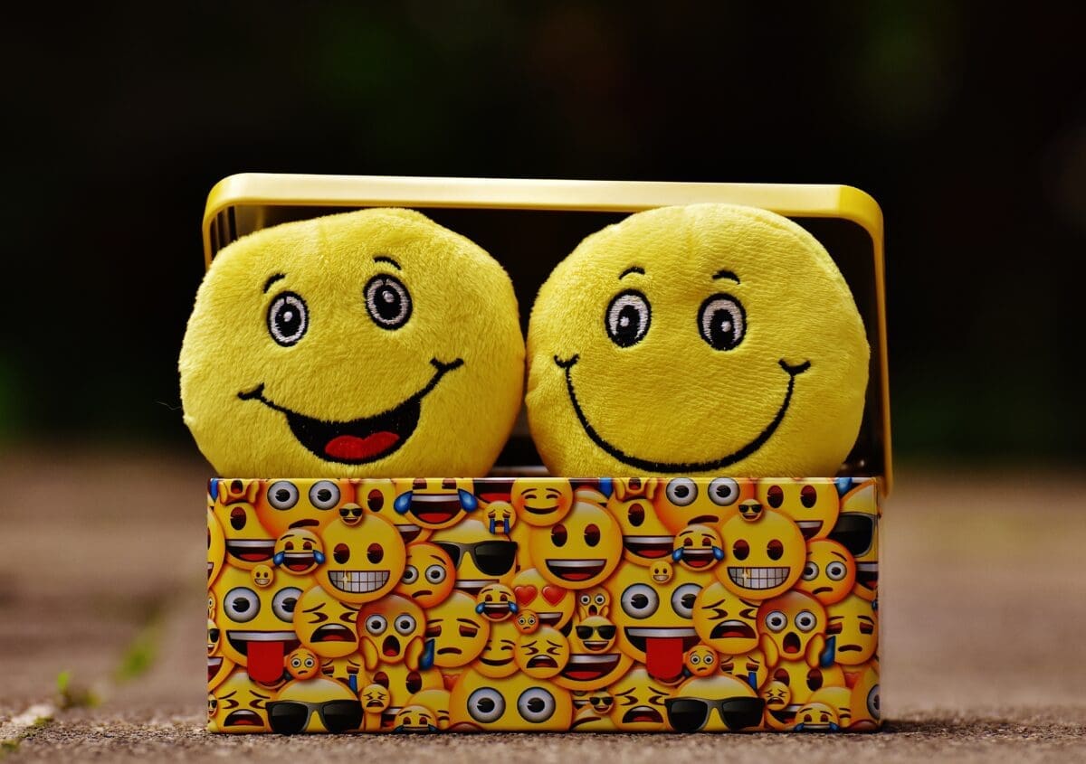 two sponge, yellow smileys popping out of a box with yellow emojis prints
