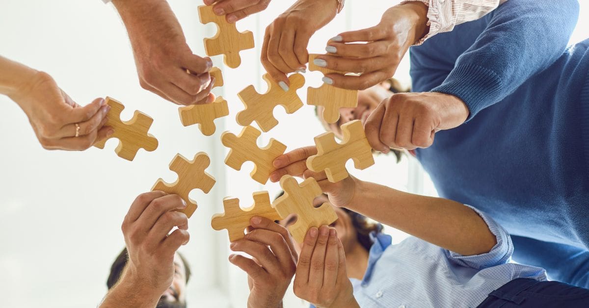 B2B marketing team members holding pieces of a puzzle & putting it together