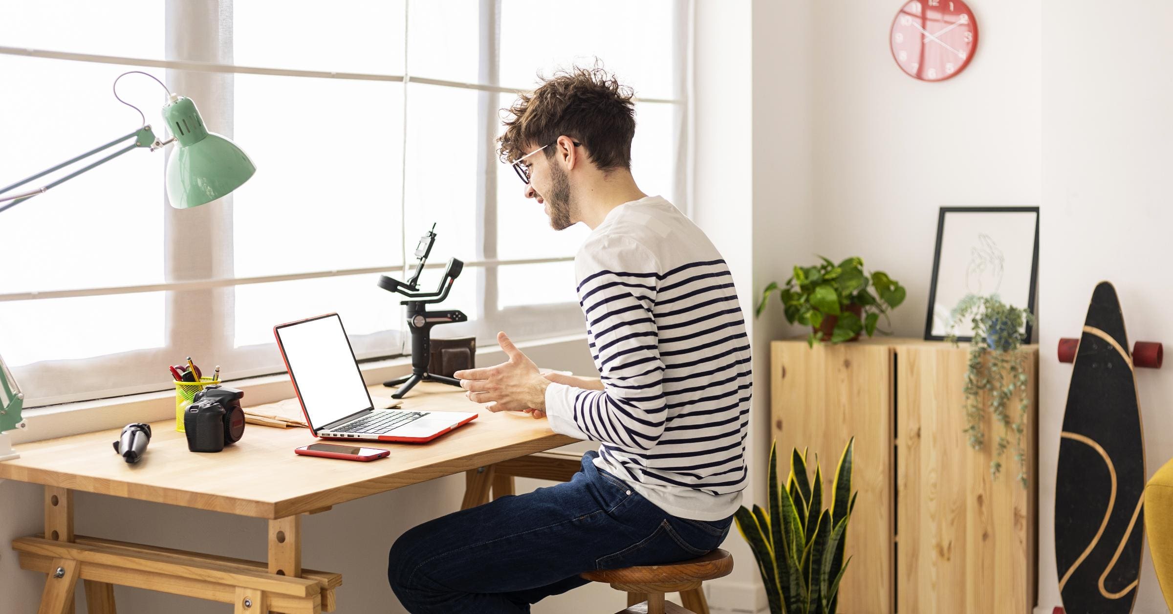 A content creator or marketer working on a laptop in a visually appealing workspace, surrounded by elements that represent various content formats, such as a camera for video, a microphone for podcasting, and a notebook for writing.